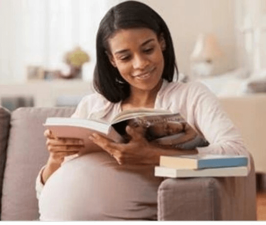 a pregnant lady reading a book